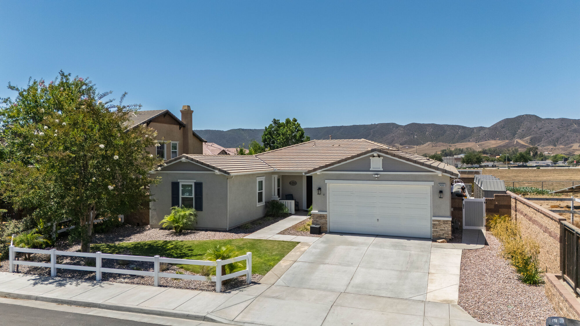 Aerial view of a single-story home with hills in the distance
