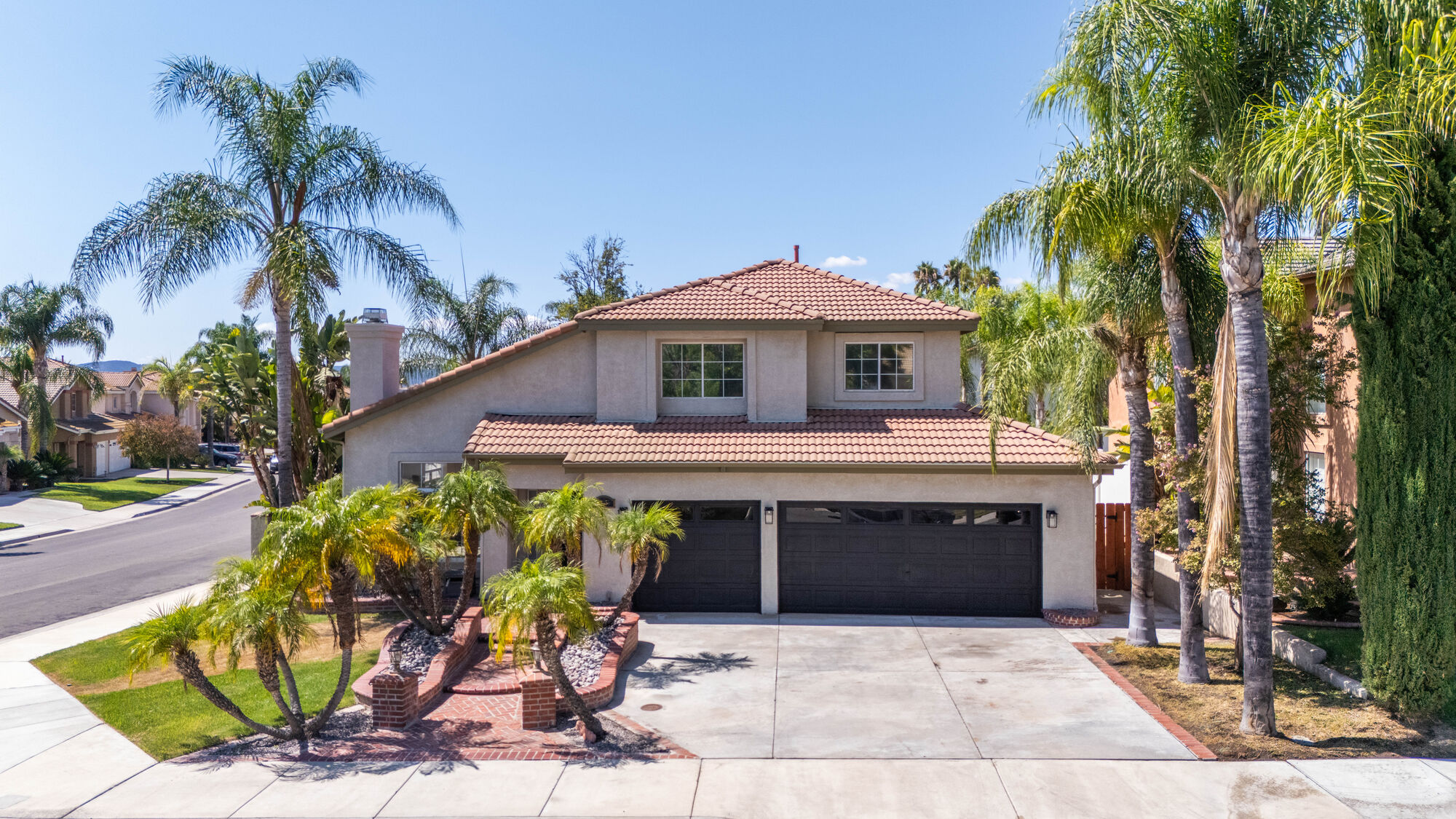 Aerial front view of a palm-lined two-story home