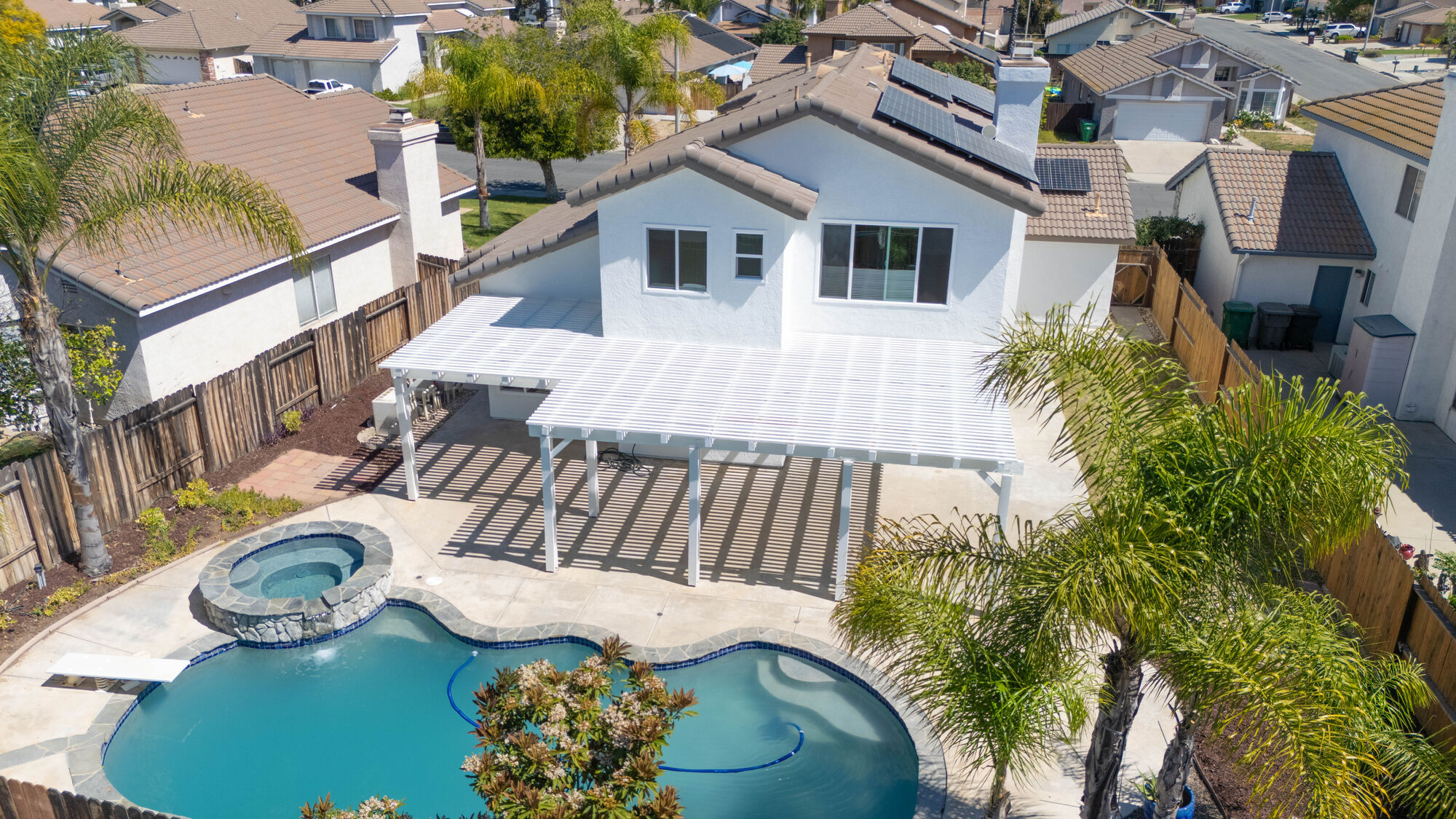 Aerial view of a backyard pool framed by neighboring homes