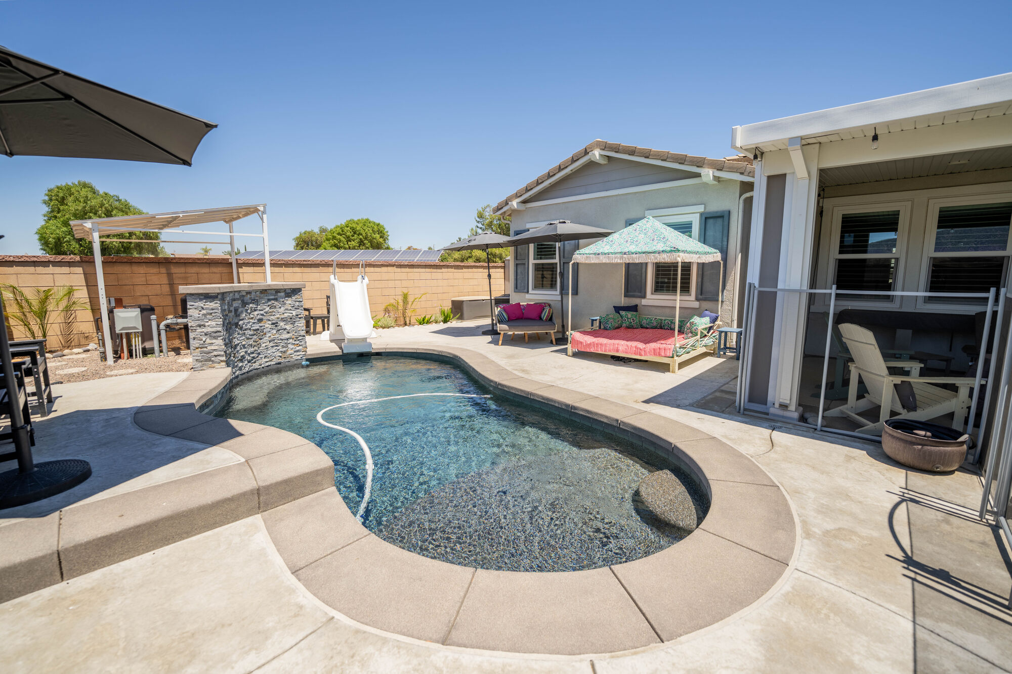 Backyard swimming pool and covered patio photographed in daylight