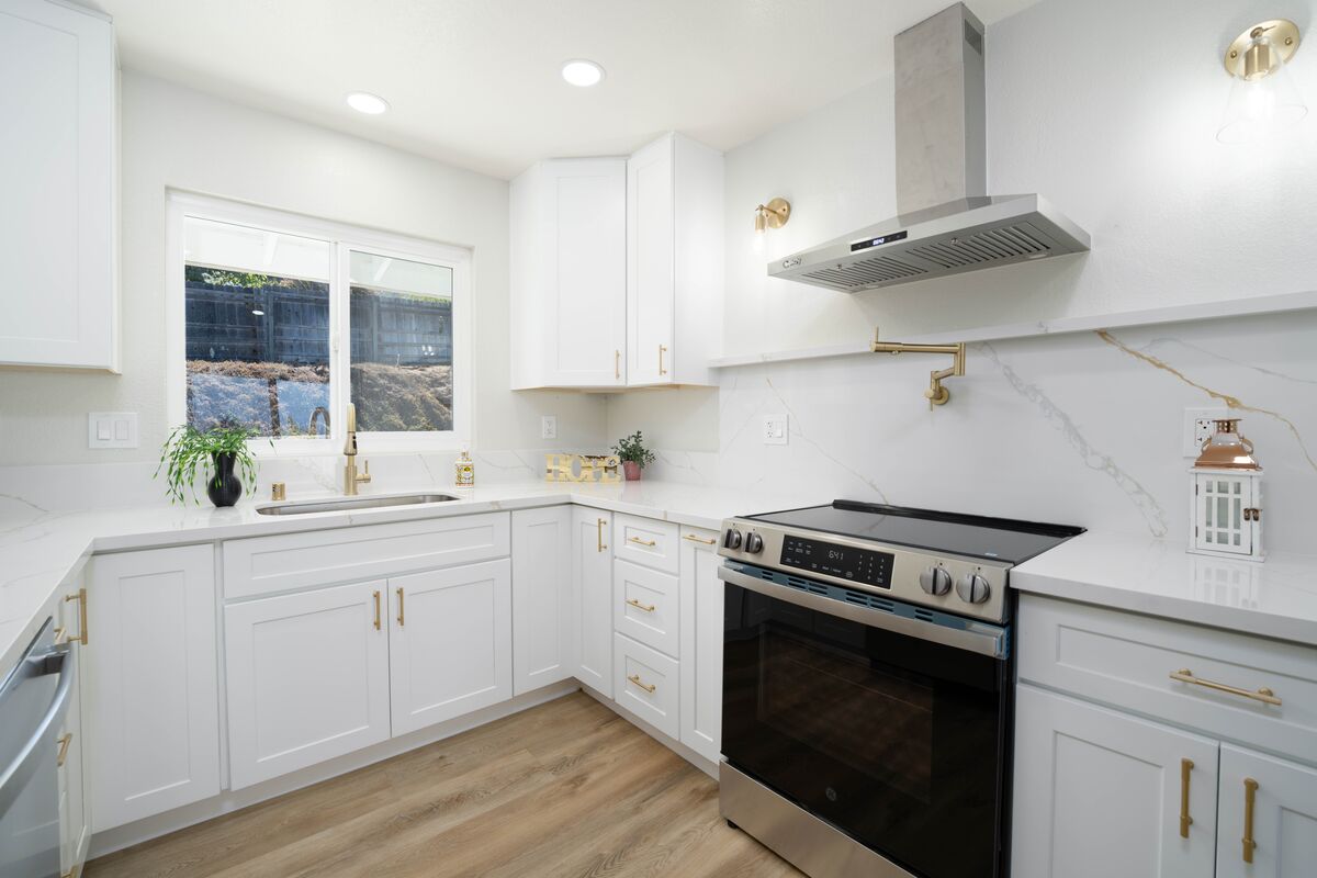 White kitchen with gold fixtures photographed for a real estate listing