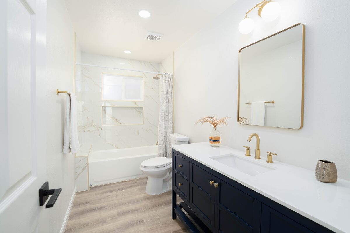 Updated bathroom with a navy vanity captured with balanced real estate photography